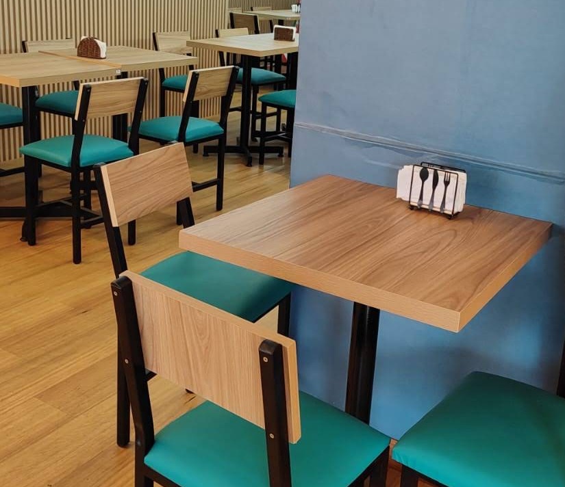Mesa para dos comensales con sillas turquesa y vista a los arcos marinos