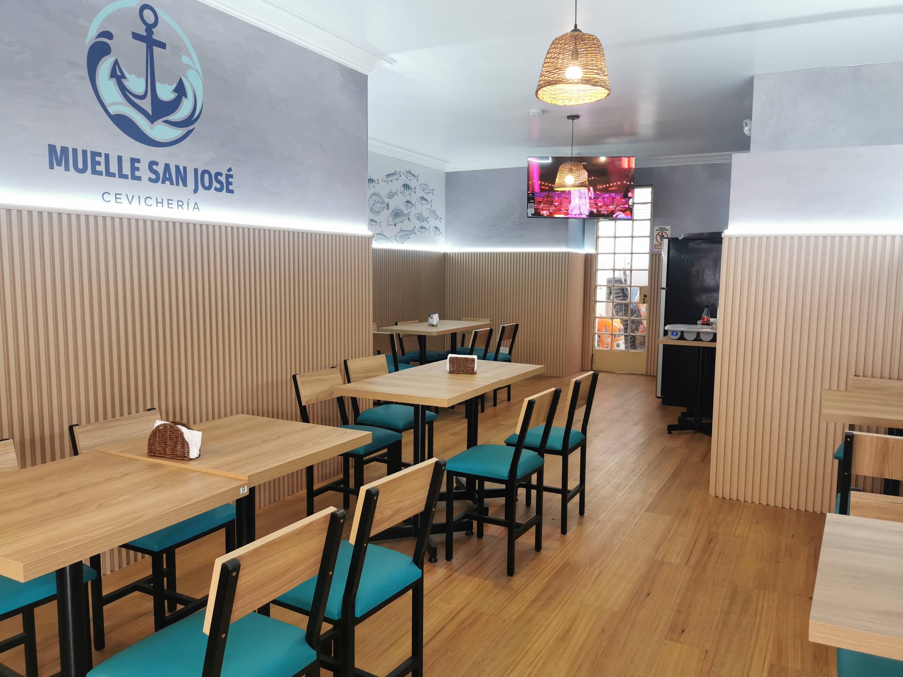 Zona de salón interior con panelado de listones de madera clara e iluminación LED perimetral